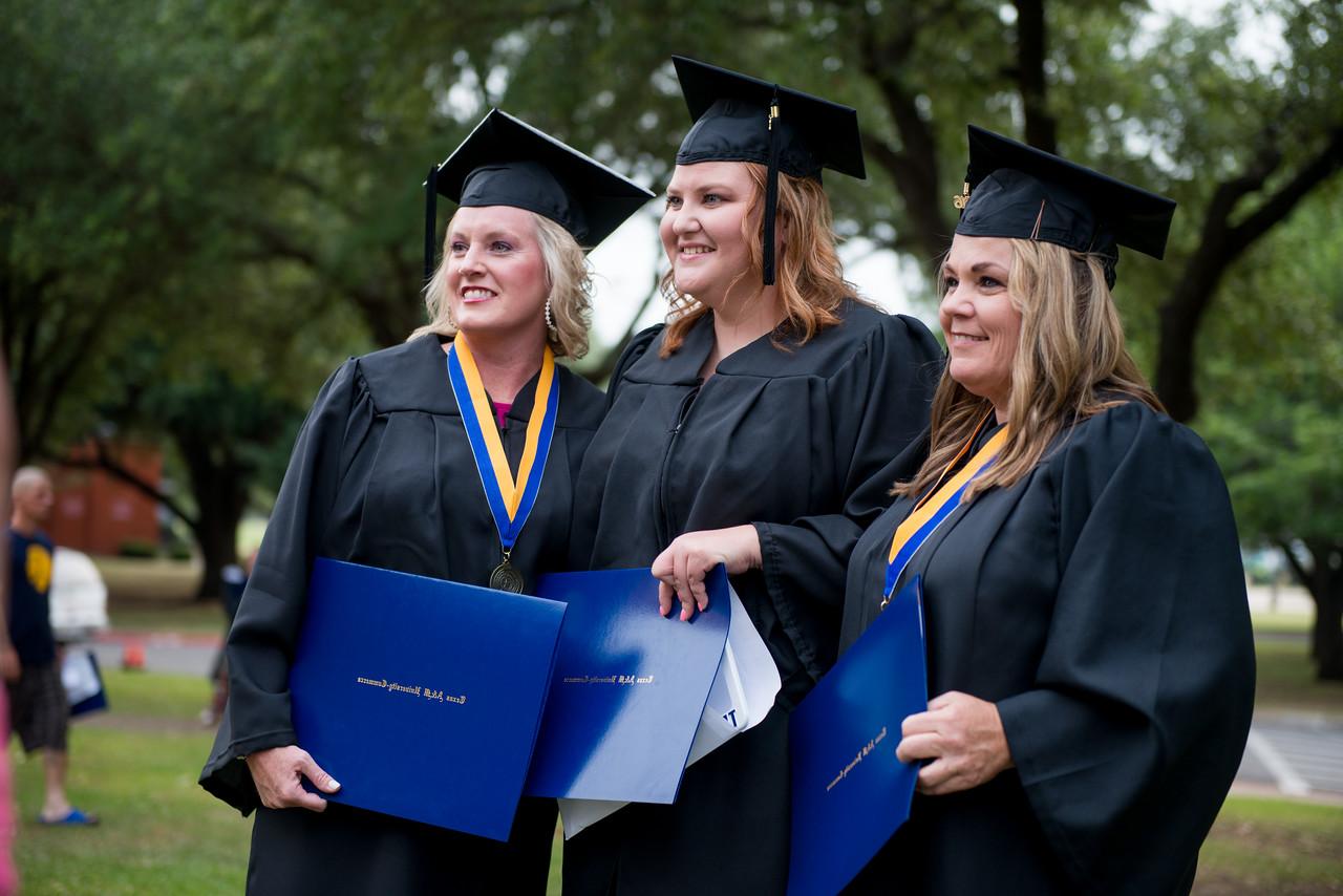 三个女毕业生拿着她们的文凭在聊天.