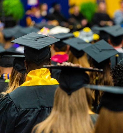 一群毕业的学生戴着帽子面朝前.